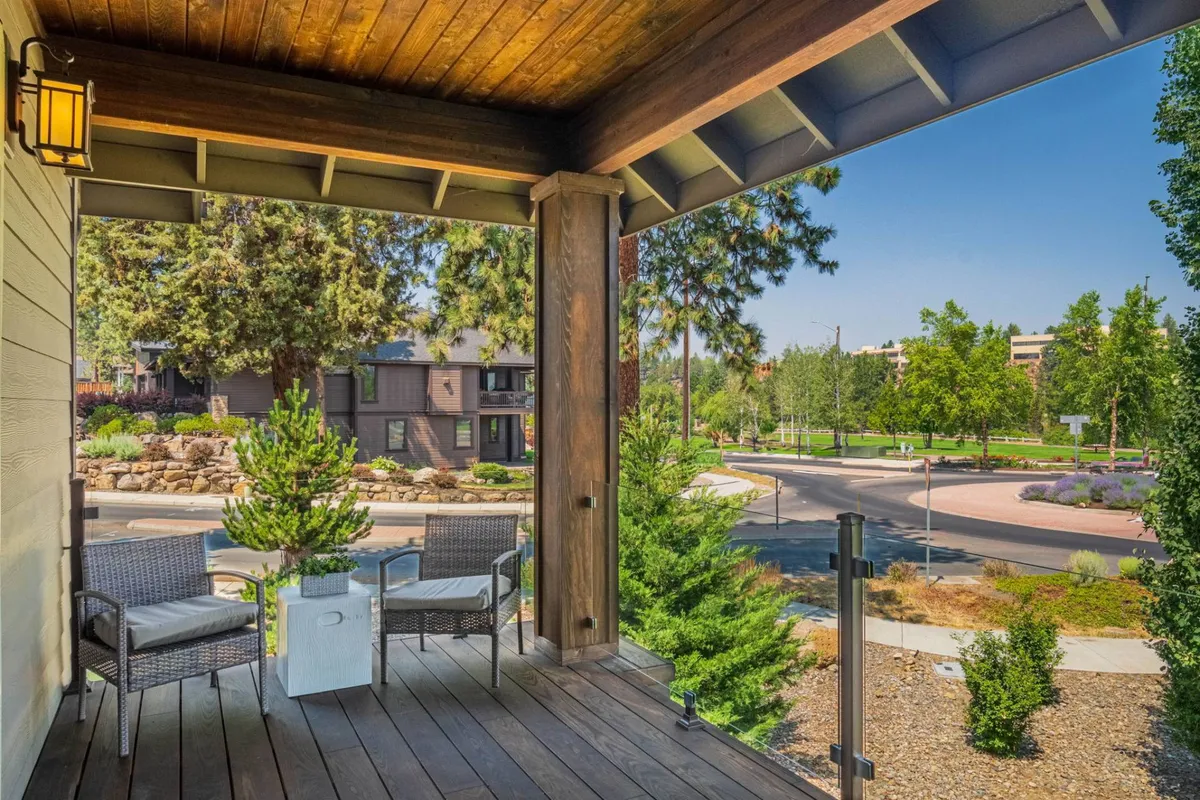 A tranquil scene with chairs on the porch, a potted plant, and views of the neighborhood, suggesting a connection to the surrounding community and the outdoors. The seating area is perfect for relaxing after a day spent exploring Bend.